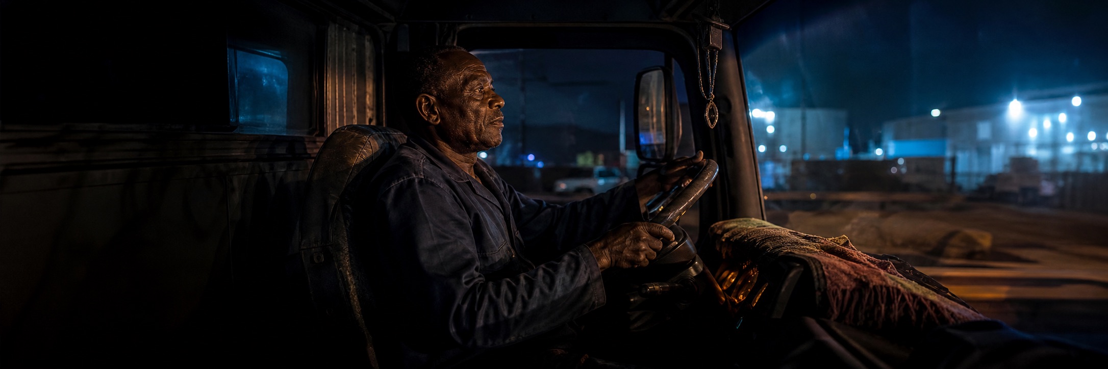 A Congolese truck driver focused on the road at night