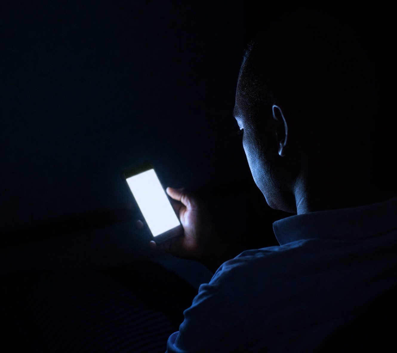 A fleet operator checking a phone alert in the middle of the night