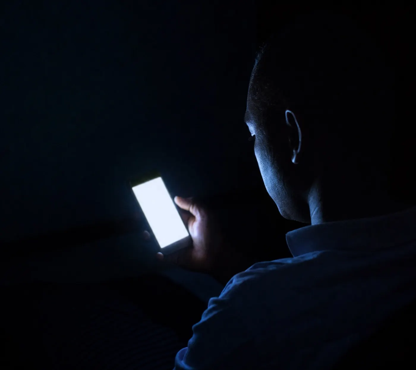 Un gestionnaire de flotte lit une alerte sur son téléphone en pleine nuit